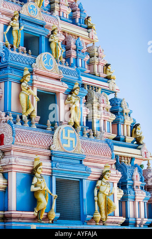 Indian gopuram temple architecture against a bright blue sky. Entrance to Sathya Sai Baba ashram. Puttaparthi, Andhra Pradesh, India Stock Photo