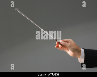 Male conductor’s hand holding baton Stock Photo