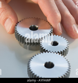 Man reaching for cog wheels Stock Photo