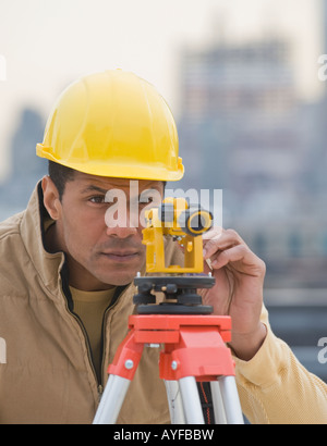 African male surveyor looking through measuring device Stock Photo