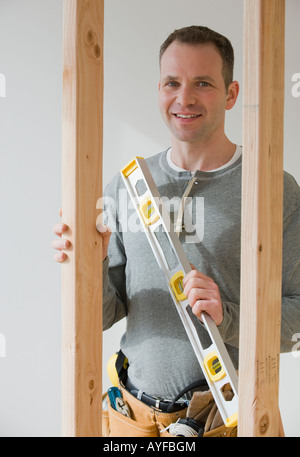 Male construction worker holding level tool Stock Photo