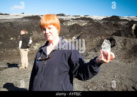 Woman holding a lump of ice from the Solheimajokull Glacier, South Shore, Iceland Stock Photo