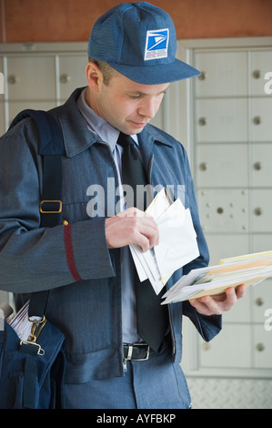 Male postal worker looking at mail Stock Photo