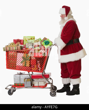 Santa Claus pushing shopping cart full of gifts Stock Photo