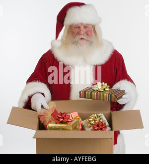 Santa Claus packing gifts in box Stock Photo