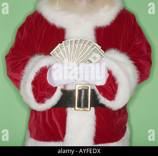 Santa Claus holding fanned out money Stock Photo