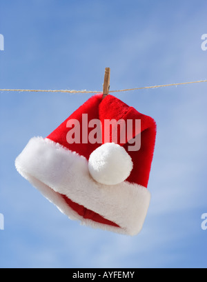Santa Claus hat hanging on clothesline Stock Photo