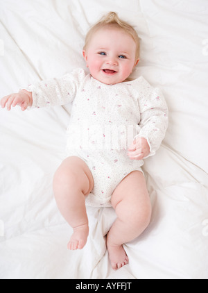 Baby laying on bed Stock Photo