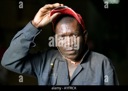 Africa Kenya Ruira MR Portrait of Worker inside sorting plant while unloading bags of ripe Arabica coffee beans during harvest Stock Photo