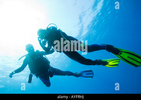 Africa Tanzania Zanzibar Matemwe Bay Silhouette of scuba divers ascending toward surface of Indian Ocean Stock Photo