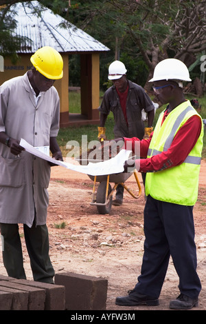 Construction workers discussing project while building village community centre for benefit of local village, Ghana, West Africa Stock Photo