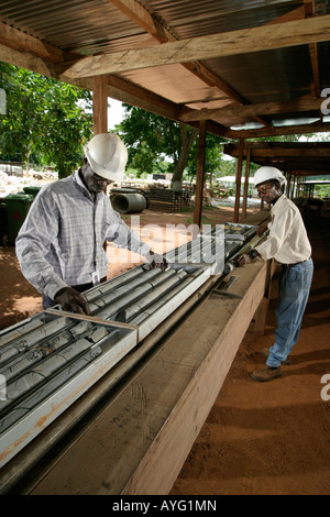 Technical logging and measuring of core samples in core shed by geologists, surface gold mine, Ghana, West Africa Stock Photo