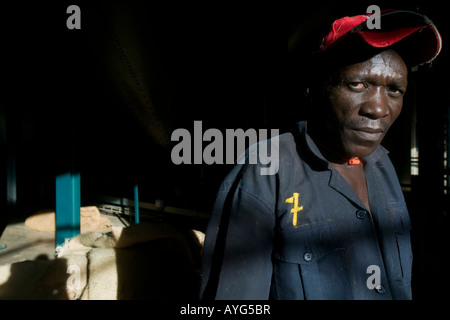 Africa Kenya Ruira MR Portrait of workman taking break from carrying bags of freshly picked Arabica coffee beans inside sorting Stock Photo