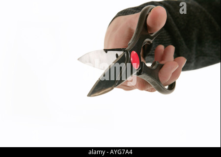 Scissors held in mans hand with white studio background Stock Photo