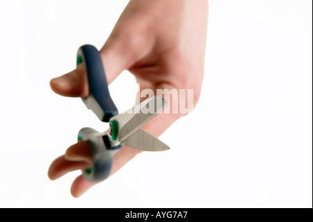 Scissors held in mans hand with white studio background Stock Photo