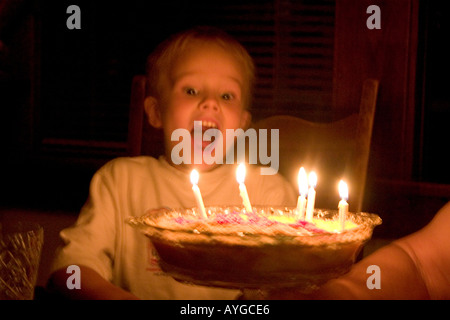 Birthday celebration for a five year old boy blowing out candles on his pie. St Paul Minnesota MN USA Stock Photo