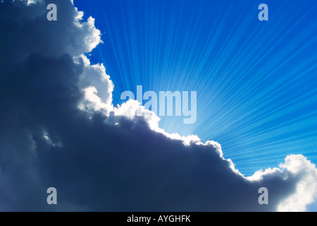 sun rays emerging from behind clouds Stock Photo