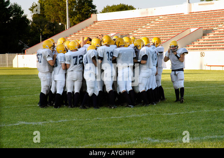 Football players plan with coaches before playing in a game Stock Photo