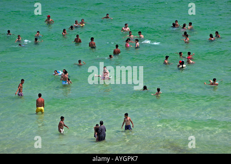 Holidaymakers swim bathe and cool off in shallow water Boujaffar Beach Sousse Tunisia Stock Photo