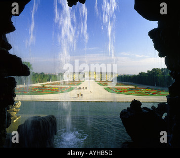 View down drive taken from behind a sunlit curtain of water from ornamental waterfall at The Schonbrunn Palace Gardens Vienna Stock Photo