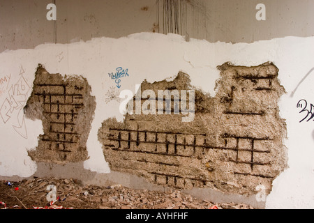 Render hacked off the concrete to reveal rusty reinforcement bars underneath Heads of the Valleys Road Abergavenny UK Stock Photo