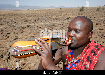 Maasai elder drinks fresh milk from a gourd Stock Photo