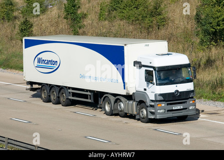 Wincanton logistics business articulated trailer behind Mercedes Benz clean white hgv Mercedes lorry truck driving along motorway Essex England UK Stock Photo