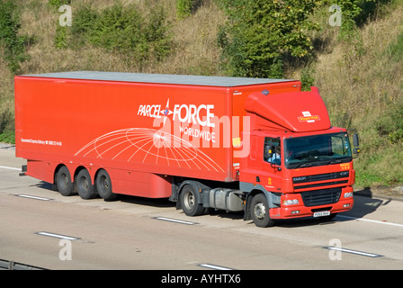 DAF red Parcel Force side & front view hgv lorry truck & driver towing rigid body articulated Parcel Force trailer driving along M25 UK motorway road Stock Photo