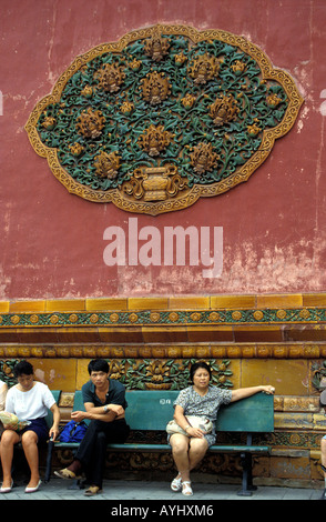 Beijing citizens resting on a bench at the wall of the forbidden city Stock Photo