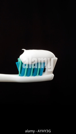 Toothpaste freshly squeezed onto a toothbrush with black background. Picture by Jim Holden. Stock Photo
