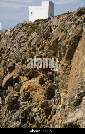 HOLYHEAD ISLE OF ANGLESEY NORTH WALES UK August Ellin's Tower on the top of South Stack Cliffs three men climbing up the cliffs Stock Photo