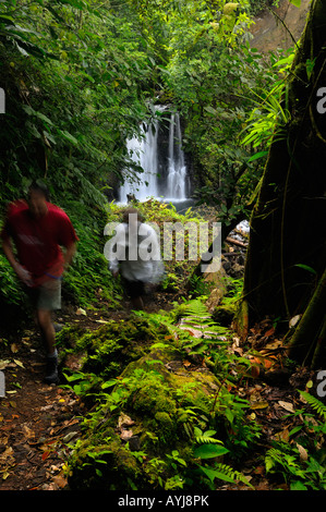 Hikers at waterfall near Chato Volcano Observatory lodge in tropical rainforest Costa Rica Stock Photo