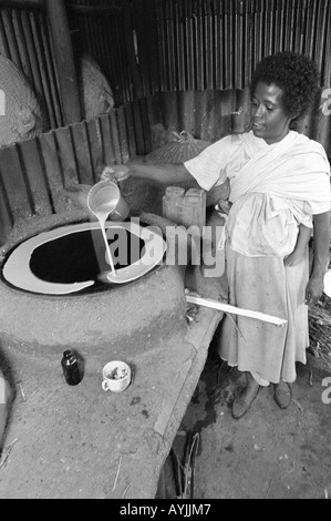 B/W of an Ethiopian woman making a traditional injera pancake on a clay stove. Mekelle, Tigray, Ethiopia, Africa Stock Photo