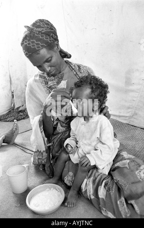 B/W of a Somali woman refugee feeding her malnourished child in an emergency feeding centre on the border with Somalia. Kebrebeyah, Ethiopia, Africa Stock Photo