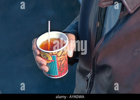 Male hand holding paper cup of hot tea Stock Photo