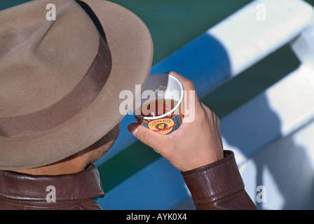 Man in fedora hat drinking a paper cuo of hot tea Stock Photo