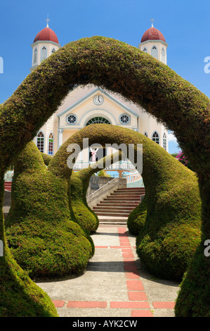 Topiary garden archways in Zarcero Francisco Alvardo Park Costa Rica with views of the San Rafael catholic church Stock Photo