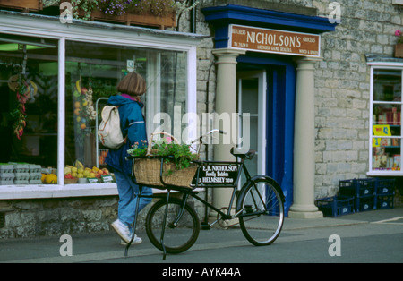 Old delivery bicycle outside a butcher and grocers shop, Helmsley, North Yorkshire, England, UK Stock Photo