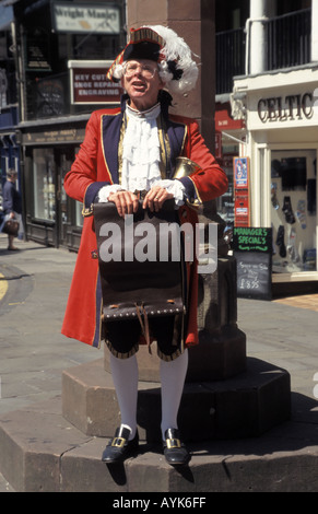 Historical city of Chester town crier wearing full regalia holding scroll & bell standing at town centre Cross in county town of Cheshire England UK Stock Photo