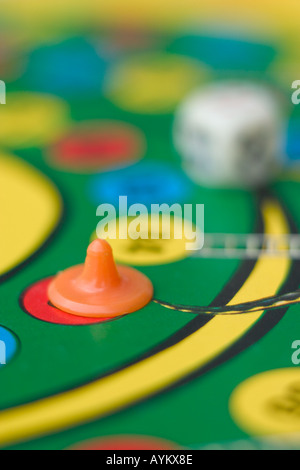 dice and piece on snakes and ladders board game Stock Photo