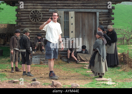 Crew member working with children on the filmset of 'Simon Magus' being shot in countryside near Llangynidr Powys South Wales UK Stock Photo