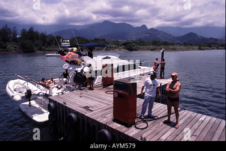 On the coast of Brazil near Angra dos Reis in Rio de Janeiro a boat stops for fuel The mountains of the Serra do Mar are behind Stock Photo