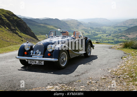 Morgan 4/4 2 seater Sports Car at the summit of Hardknott Pass, overlooking Eskdale. English Lake District Stock Photo