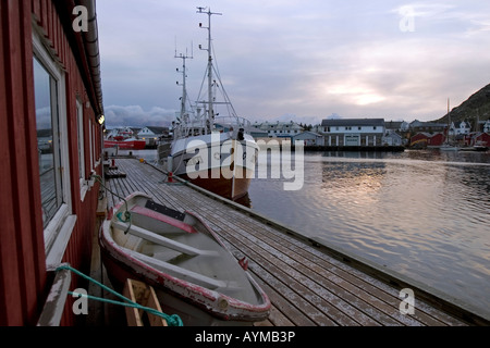 Fishing boat alongside old wooden quay at Ballstad, Lofoten, Norway Stock Photo