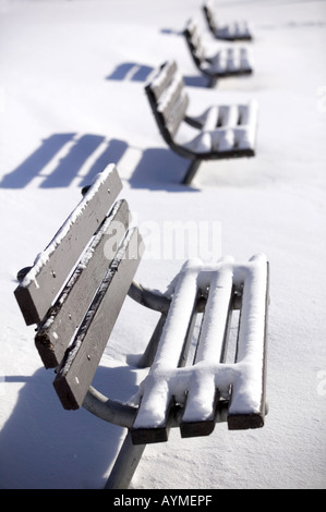 Park benches are covered with snow as winter keeps its hold on Minneapolis, Minnesota. Stock Photo