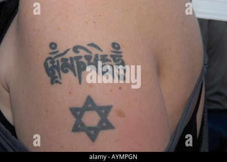 Young woman with Judaic and Tibetan tattoo mark on her arm Stock Photo