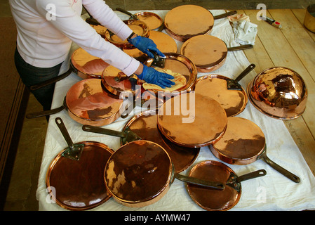 Cleaning and polishing pots and pans Stock Photo