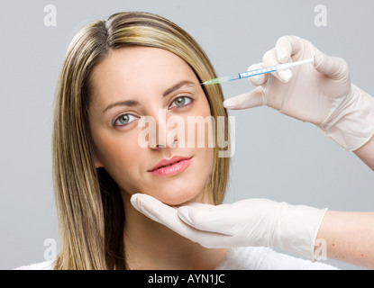 woman receiving Botox injection in eyebrow Stock Photo