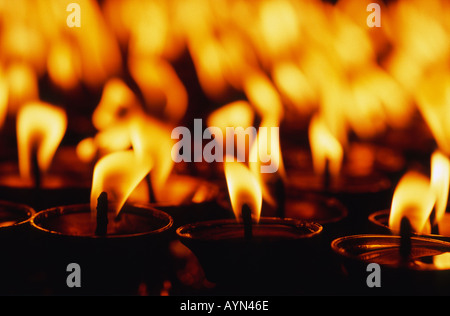 Melting wax on lighted candles reflected on a marble surface in an