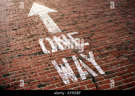 One way sign on an old red brick road Stock Photo